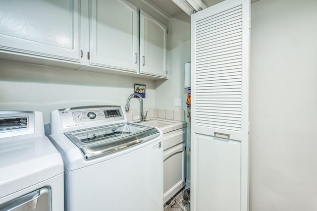 laundry room with a sink, cabinet space, and washer and clothes dryer