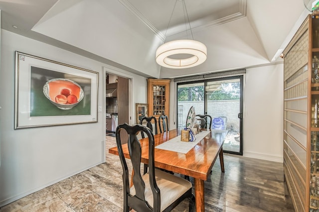 dining area with crown molding, a tray ceiling, and baseboards