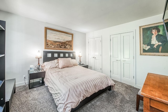 bedroom with two closets, carpet flooring, and baseboards
