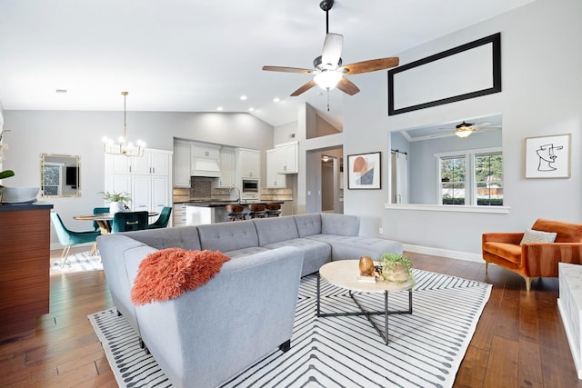 living room featuring ceiling fan with notable chandelier, high vaulted ceiling, and dark hardwood / wood-style floors