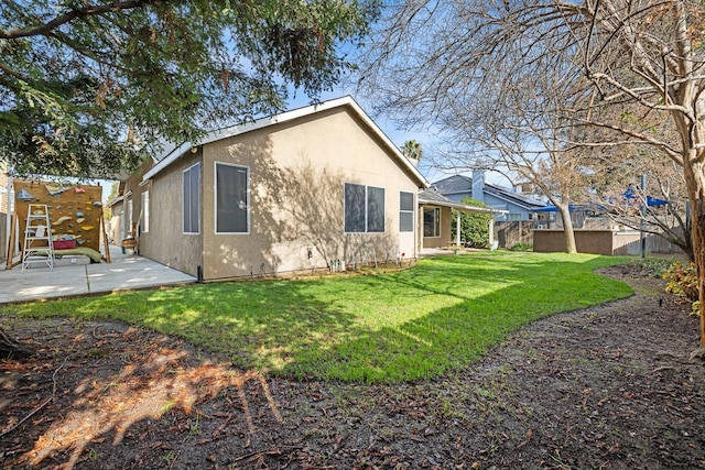 rear view of house featuring a yard and a patio area