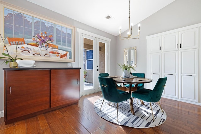 dining room featuring a notable chandelier, dark hardwood / wood-style floors, vaulted ceiling, and french doors