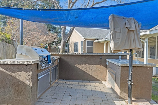 view of patio featuring grilling area, exterior kitchen, and sink