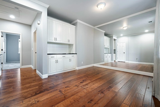 unfurnished living room with ornamental molding and dark hardwood / wood-style flooring