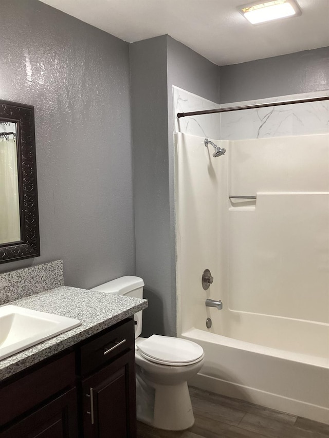 full bathroom featuring hardwood / wood-style flooring, toilet, vanity, and shower / bathing tub combination