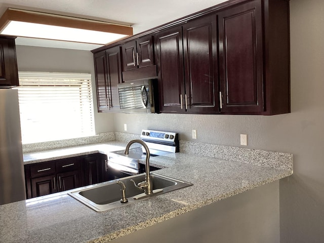 kitchen featuring stainless steel appliances, sink, and dark brown cabinetry