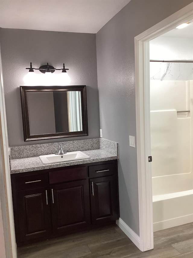 bathroom with vanity, hardwood / wood-style floors, and shower / bathing tub combination