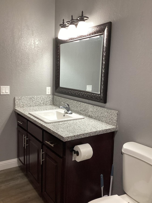 bathroom featuring vanity, hardwood / wood-style floors, and toilet