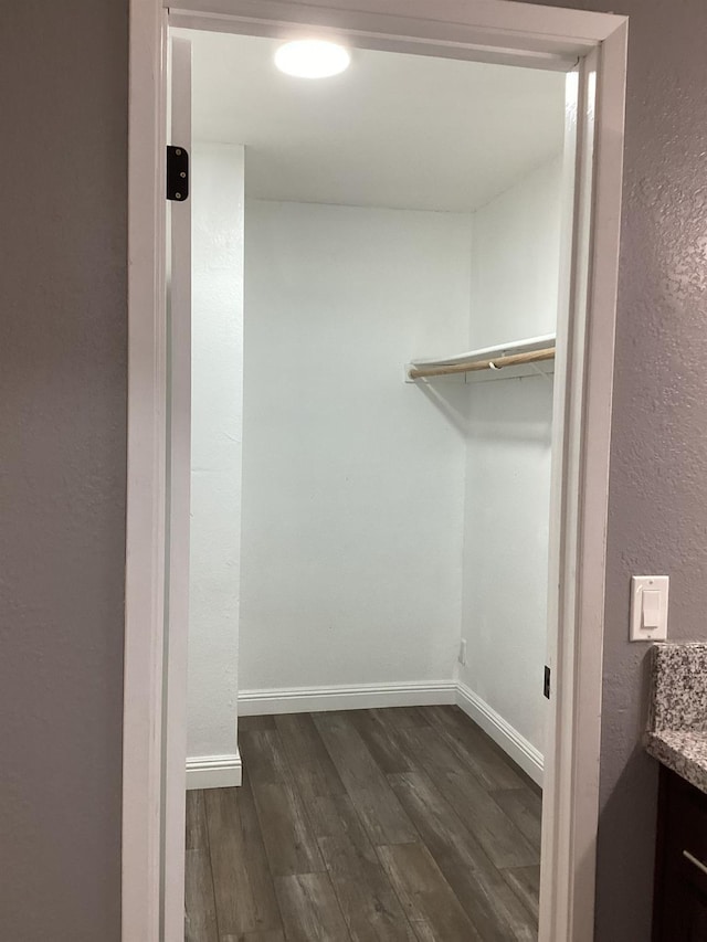 walk in closet with dark wood-type flooring