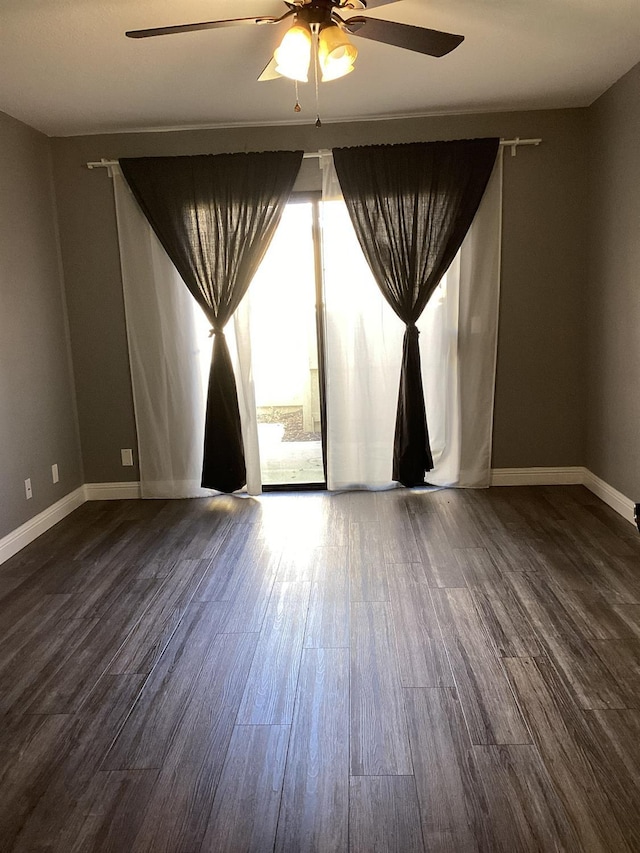 spare room featuring dark wood-type flooring and ceiling fan