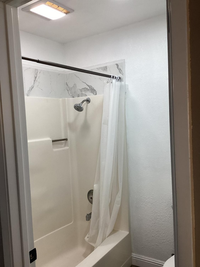 bathroom featuring shower / bathtub combination with curtain