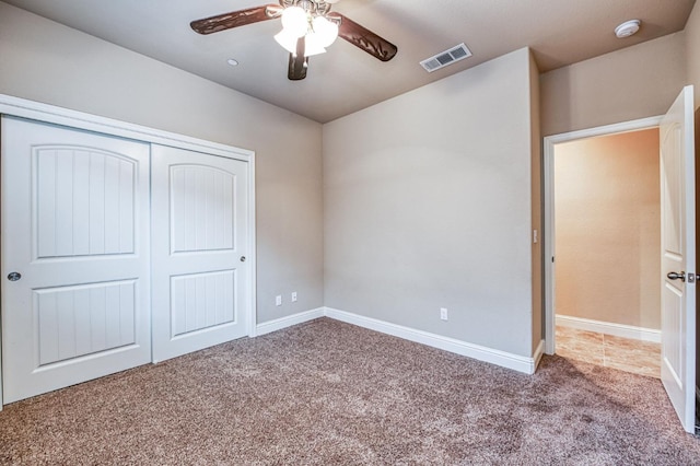 unfurnished bedroom featuring carpet, ceiling fan, and a closet