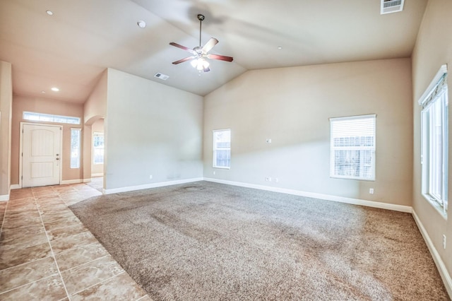 carpeted empty room featuring high vaulted ceiling and ceiling fan