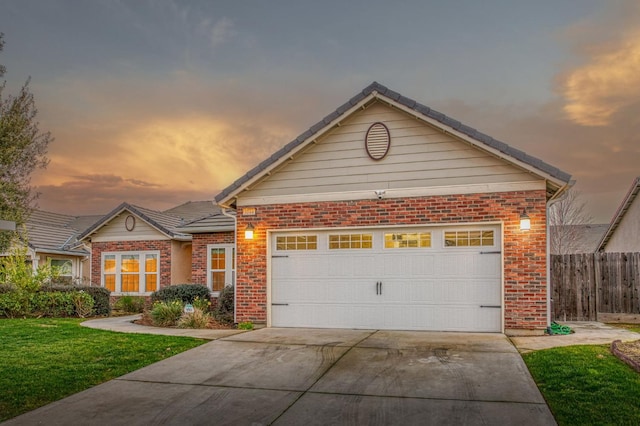 view of front of property with a garage and a lawn