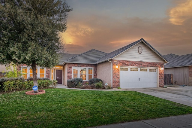 single story home with a garage and a yard