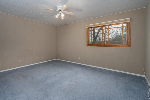 spare room featuring ceiling fan, a textured ceiling, and dark colored carpet