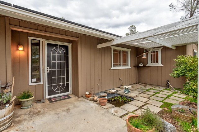 view of exterior entry with a patio area