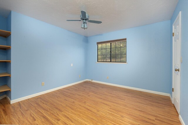 unfurnished room featuring ceiling fan, a textured ceiling, and light wood-type flooring