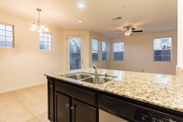 kitchen featuring sink, light stone counters, stainless steel dishwasher, pendant lighting, and ceiling fan with notable chandelier