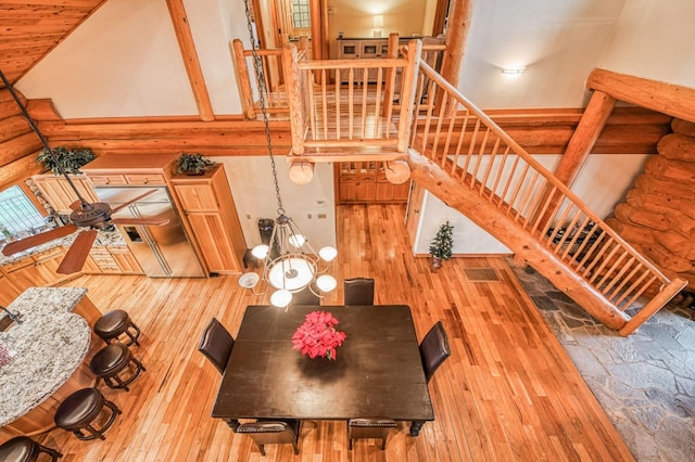 dining room featuring hardwood / wood-style floors, ceiling fan with notable chandelier, wooden ceiling, and high vaulted ceiling