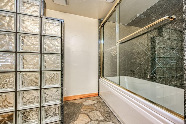 12755 Rusty Spur Ln, Clovis, CA 93619 - bathroom featuring bath / shower combo with glass door, baseboards, and stone finish flooring