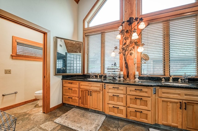 12755 Rusty Spur Ln, Clovis, CA 93619 - bathroom with stone tile floors, baseboards, toilet, and double vanity