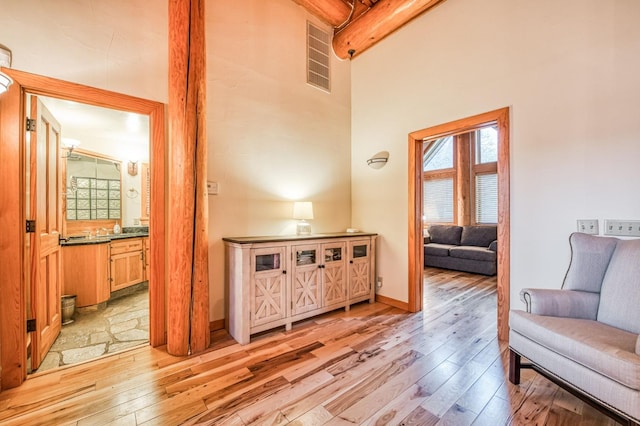 interior space featuring wooden ceiling, beamed ceiling, light hardwood / wood-style floors, and high vaulted ceiling