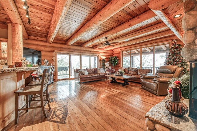 12755 Rusty Spur Ln, Clovis, CA 93619 - living room with wooden ceiling, rustic walls, light wood finished floors, beam ceiling, and a ceiling fan