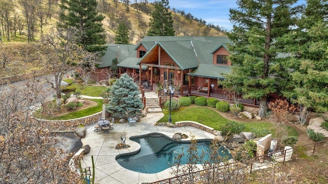 exterior space with a mountain view, a yard, a fenced in pool, and a patio area