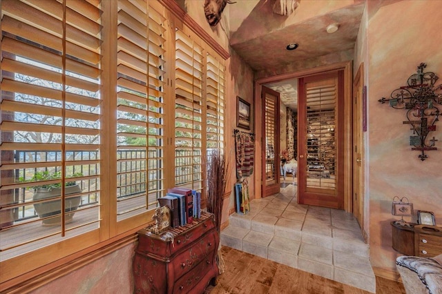 corridor featuring a high ceiling and light hardwood / wood-style floors