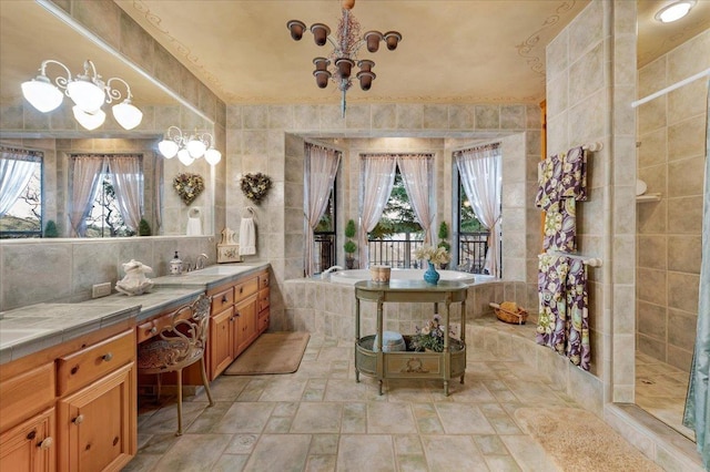 bathroom with a bath, vanity, and an inviting chandelier