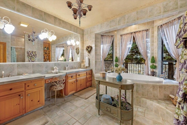 bathroom with vanity, tile walls, tasteful backsplash, tiled bath, and a chandelier