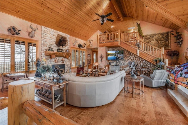 living room featuring beam ceiling, a fireplace, high vaulted ceiling, and hardwood / wood-style flooring