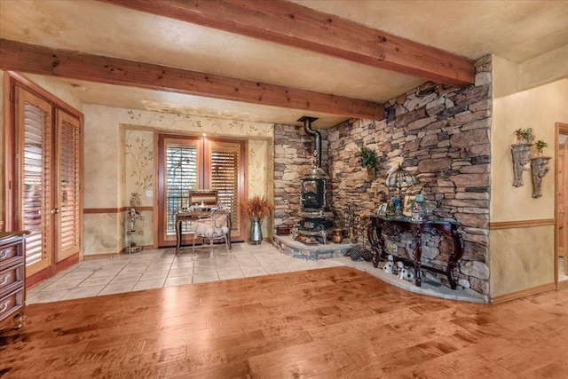 unfurnished living room featuring beamed ceiling and light hardwood / wood-style flooring