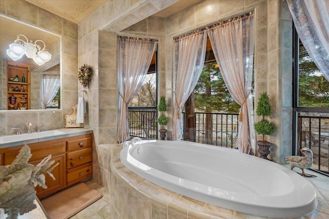 bathroom with vanity, tile walls, and tiled tub