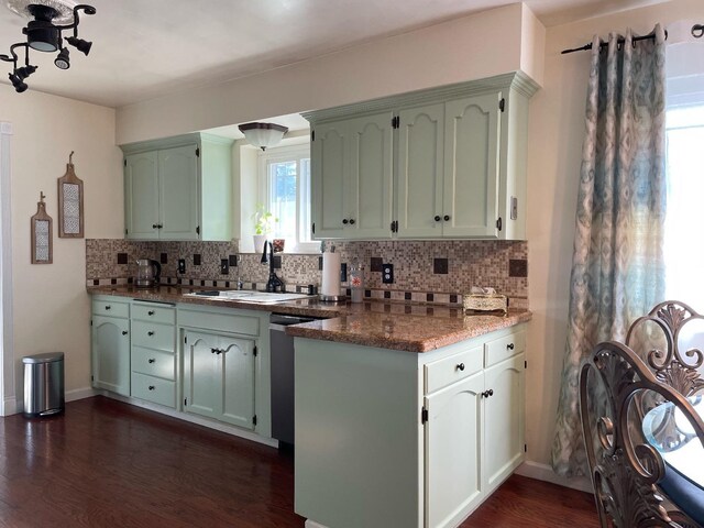 kitchen with dark hardwood / wood-style floors, dishwasher, sink, dark stone counters, and green cabinetry