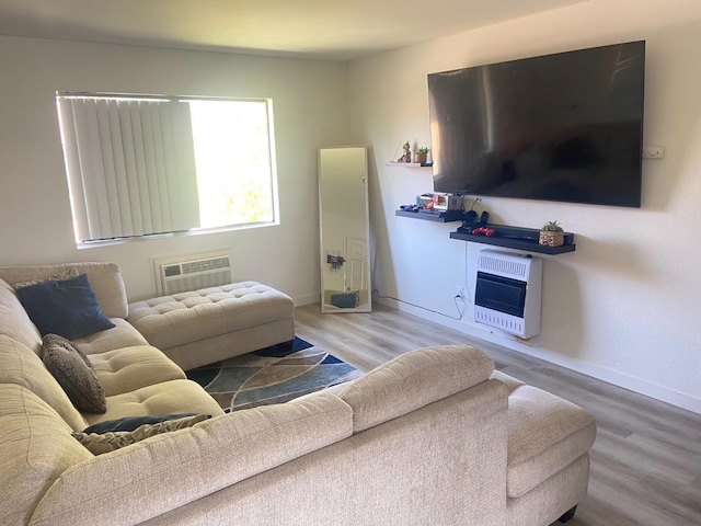 living room with hardwood / wood-style flooring, a wall mounted AC, and heating unit