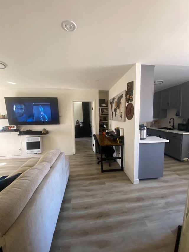 living room featuring dark hardwood / wood-style flooring, sink, and heating unit