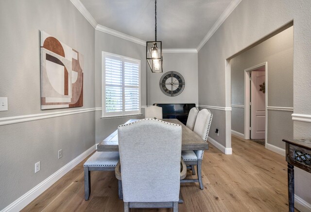 dining space with light hardwood / wood-style floors and crown molding