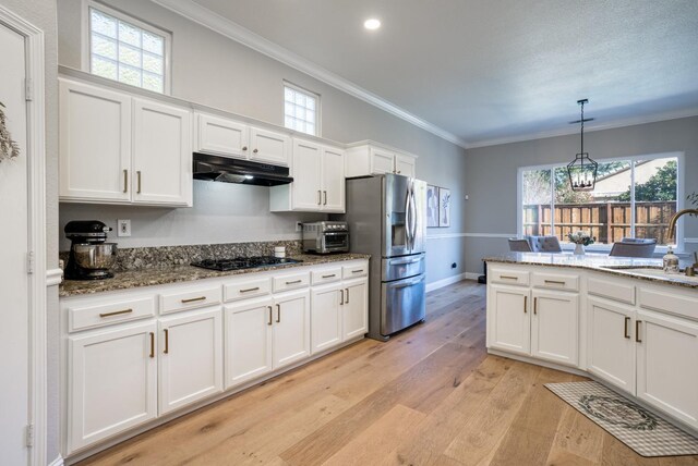 kitchen with stainless steel fridge, white cabinetry, black gas cooktop, and an inviting chandelier