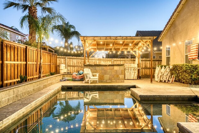 pool at dusk with a pergola and a wooden deck