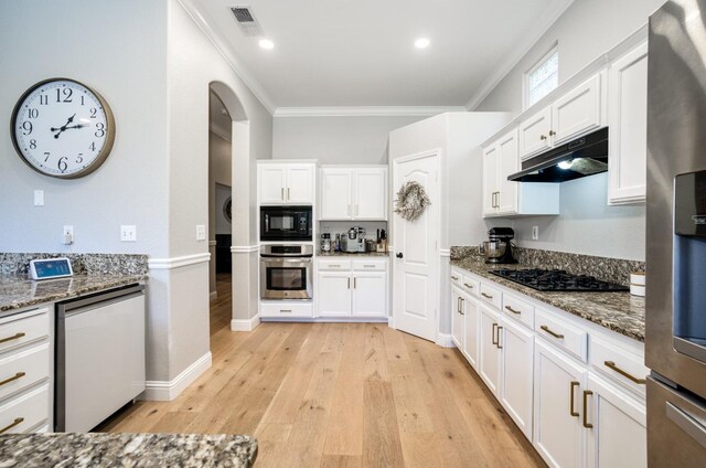 kitchen featuring dark stone counters, white cabinetry, black appliances, and ornamental molding