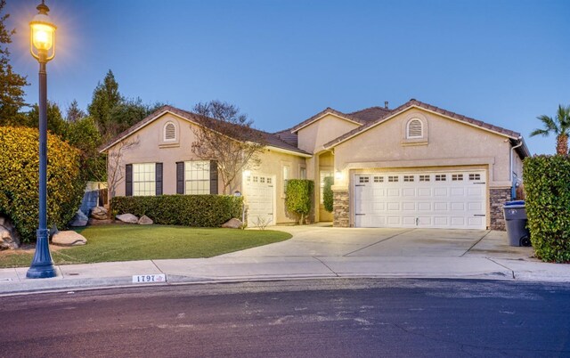 view of front of property featuring a garage and a lawn