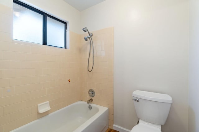 bathroom featuring tiled shower / bath combo and toilet