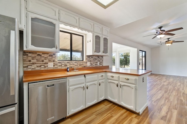 kitchen with decorative backsplash, appliances with stainless steel finishes, white cabinetry, and sink