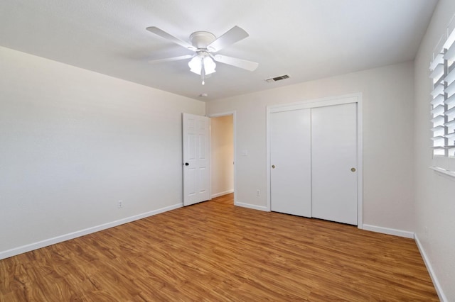 unfurnished bedroom featuring hardwood / wood-style flooring, ceiling fan, and a closet