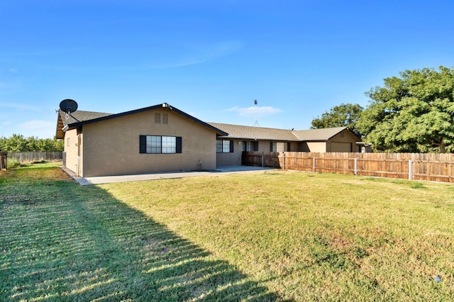 rear view of property featuring a yard and a patio