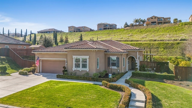 mediterranean / spanish-style home with a garage and a front lawn