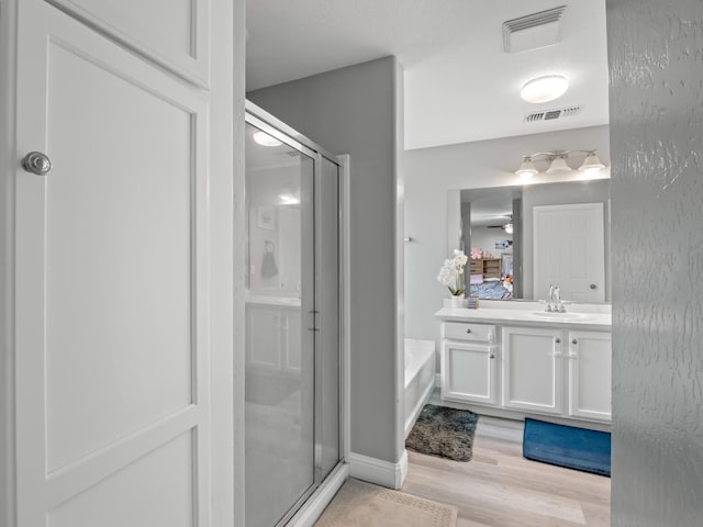 bathroom featuring vanity, hardwood / wood-style flooring, and independent shower and bath