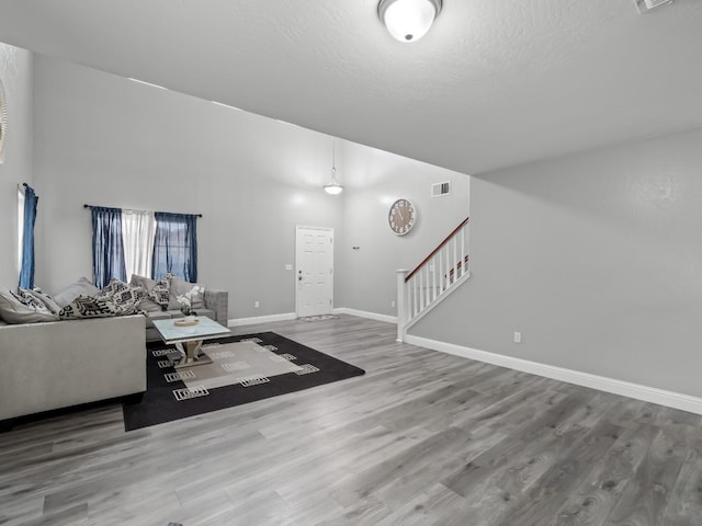 unfurnished living room with hardwood / wood-style floors and a textured ceiling